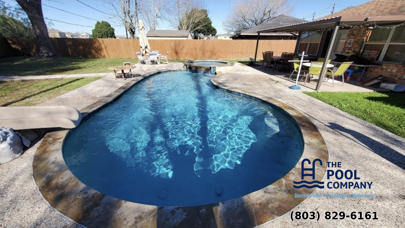 Freeform pool with attached spa and water slide